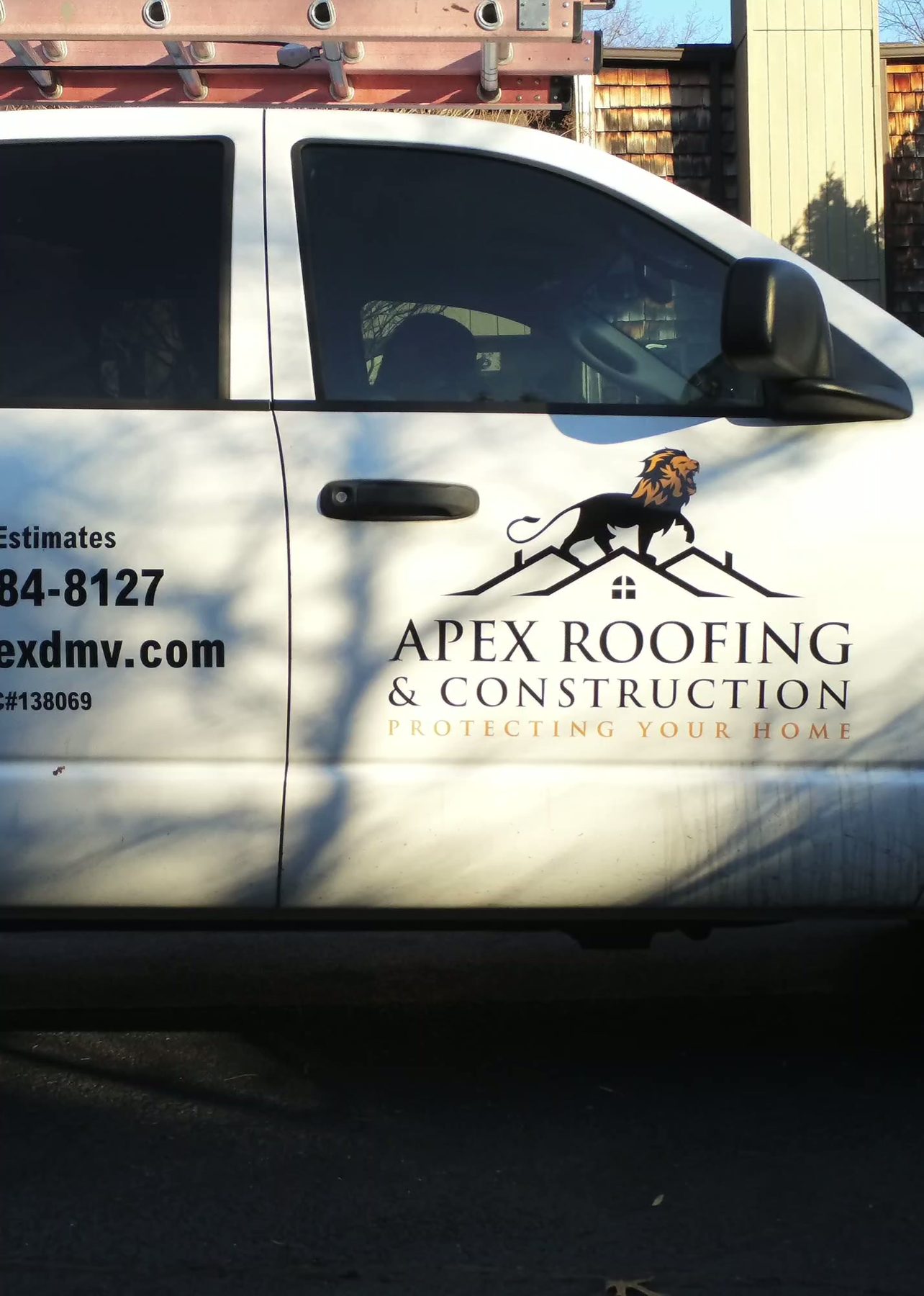 Close-up of the Apex Roofing and Construction logo on the company truck