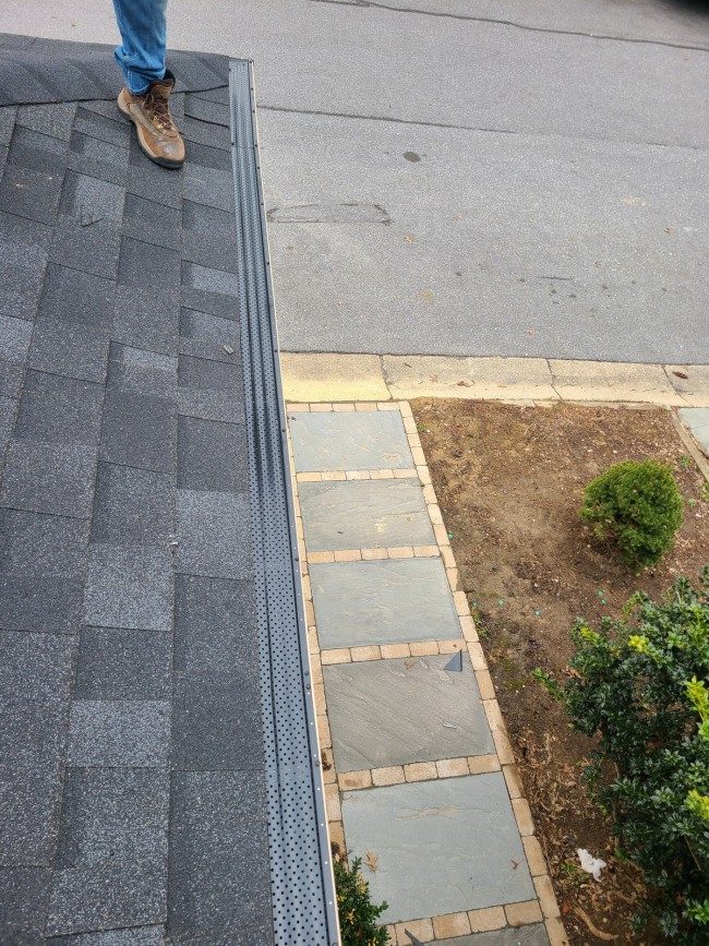 Cleared gutter along a roof edge after a gutter cleaning service